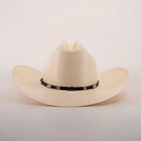 The 5000x Sinaloa Straw Hat is a beige cowboy hat featuring a black band with metal accents. Its high crown and wide brim highlight exceptional craftsmanship, set against a plain white background.