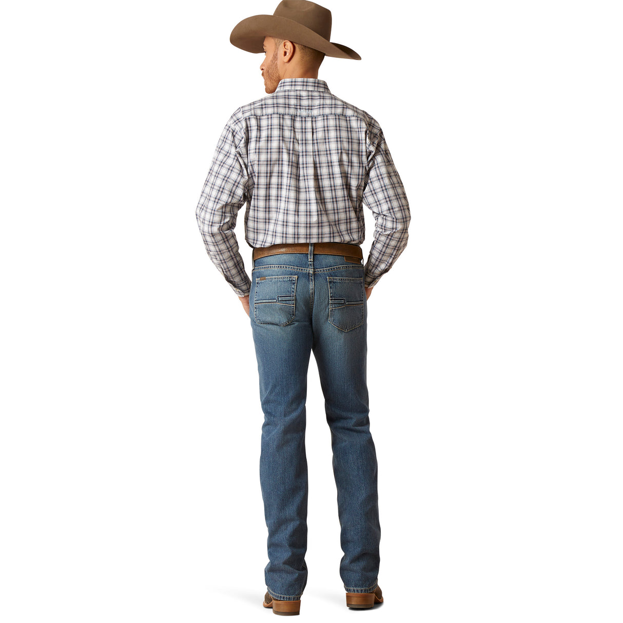 A modern cowboy stands with his back to the camera, wearing a plaid shirt, Ariat M7 Slim Ezra Straight Jeans - Brighton (10045388), brown boots, and a cowboy hat.