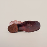 Bottom view of a Grisly Brown - Rodeo Toe cowboy boot on its side against a white background. The premium cowhide sole features logo engravings and small circular indents, with a squared toe and visible stitching around the edge.