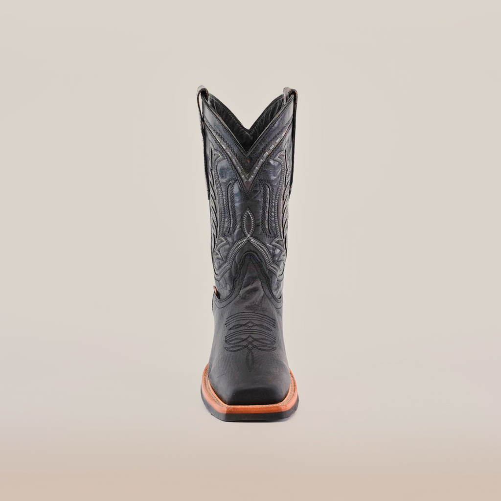 The Cheyenne Black boot with a Rodeo Toe, made from premium cowhide leather, showcases intricate front stitching on a white background. It features a brown slip-resistant sole for style and practicality.