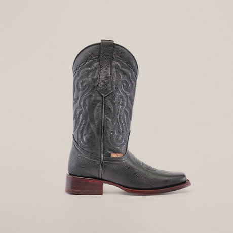 A Grisly Black - Rodeo Toe cowboy boot is displayed against a white backdrop, featuring a leather upper with intricate stitching and detailed patterns. Crafted from premium cowhide leather, it boasts a wooden heel, highlighting exceptional craftsmanship.