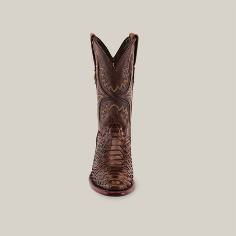 A brown cowboy boot, the Exotic Python model, stands out against a plain background with its intricate python skin pattern and round toe. The embossed details and shaft stitching highlight the mix of textures, capturing the essence of Western elegance.