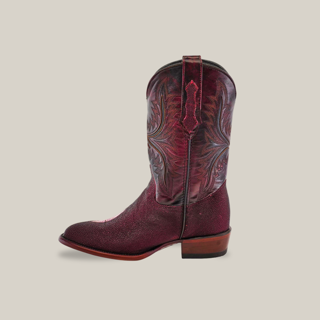 A side view of the Exotic Stingray - Wine - Round Toe cowboy boot highlights its intricate shaft stitching, crafted from stingray leather, featuring a round toe and wooden heel against a plain backdrop.