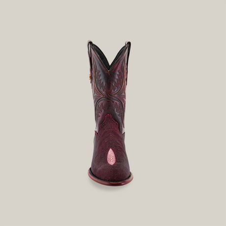 Front view of the Exotic Stingray - Wine - Round Toe childrens cowboy boot made from maroon and dark brown leather with intricate patterns, featuring a decorative cutout near the toe and exotic stingray accents on a light beige background.