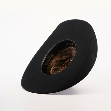 Against a light background, the 6X Brazil Black hat features a wide brim tilted at an angle. Made from premium Brazil felt, it has an inner lining with intricate brown and gold patterns reflecting Western heritage, exuding a modern and artistic design.