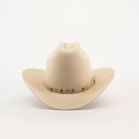 The 6X 2 Carnales Bone is a cream-colored felt hat with a wide brim and a decorative band featuring small conchos encircling the crown, set against a plain white background.