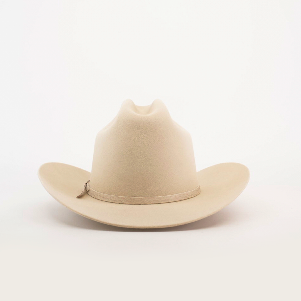 The 6X 2 Carnales Bone, a classic western beige felt cowboy hat with a wide, curved brim and crown crease, is featured against a plain white background.