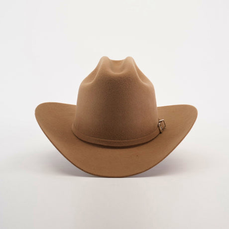 The 6X 2 Carnales Fawn is a classic brown cowboy hat made from sheep wool, with a wide brim and decorative band featuring a small metal buckle. Set against a plain white background, this quintessential western headwear is perfect for any adventurer.