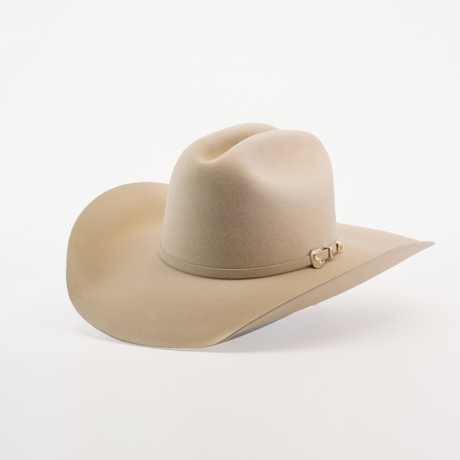 The 100X Tony Lama Belly is a beige cowboy hat crafted from premium beaver fur, exuding Western elegance with a wide brim and metal-accented decorative band, beautifully set against a plain white background to embody true Western spirit.