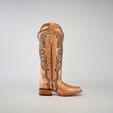 A single Eden Rose Gold cowboy boot with intricate black embroidery on a shiny surface, featuring a wooden heel and narrow square toe, set against a plain gray background.