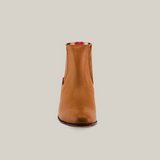 The Grasso Honey - Round Toe is a brown leather ankle boot showcasing luxury Western craftsmanship. It features premium leather with side elastic panels, complemented by a short black heel against a white background.