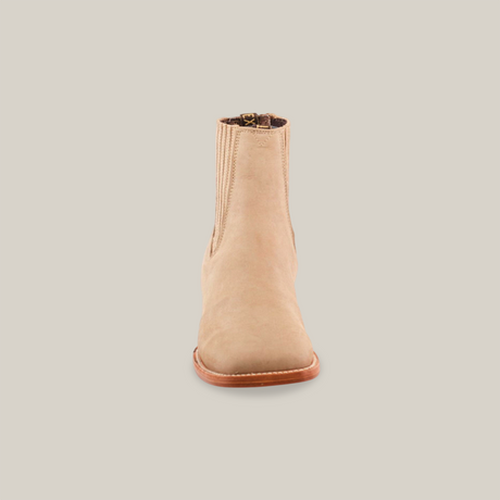 Centered on a plain white background is the Prime Suede Pearl Square Toe boot, a beige suede ankle-length cowboy-style ankle boot featuring stretch panels and a brown sole, epitomizing an elegant and versatile design.