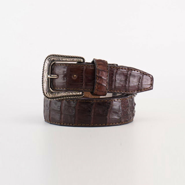 The Exotic Full Quilt Caiman – Texas Buckle – Brown Belt, featuring a crocodile-patterned design and a decorative silver buckle, exudes Western appeal as it lies coiled against a plain white background.