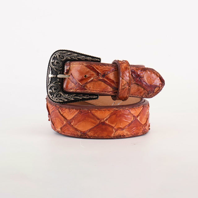 The Exotic Full Quilt Pirarucu Fish -Texas Buckle - Brandy Belt features a textured brown leather with an embossed pattern and a Texas-style silver buckle adorned with intricate floral engravings, demonstrating exceptional craftsmanship. It is artfully rolled up against a white background.