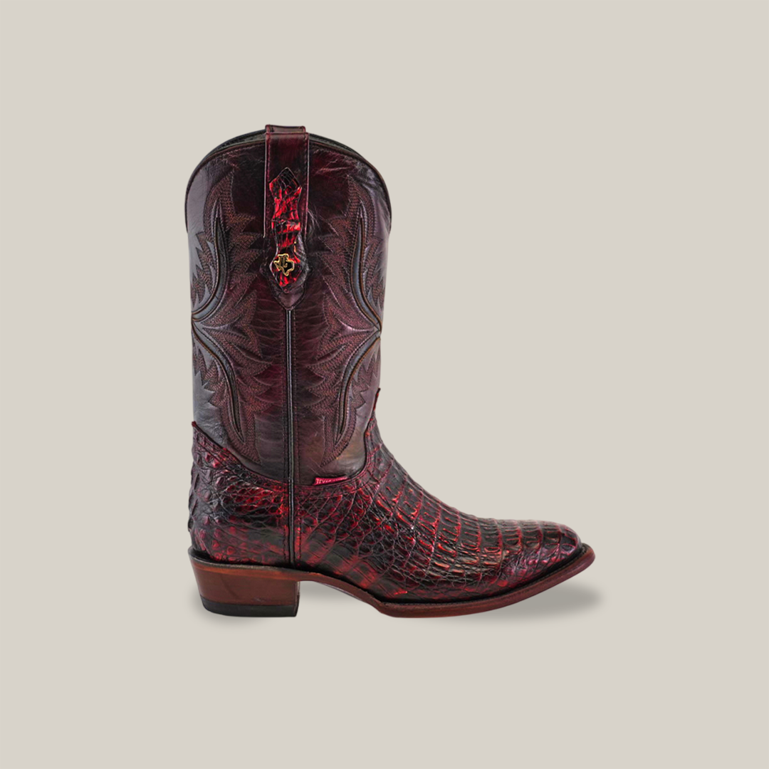 The Exotic Caiman Hornback - Black Cherry boots showcase intricate patterns on a red and black shaft with exotic scales on the foot, against a plain background. Featuring a round toe and low heel, this design is captivating.