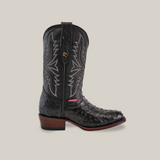 A black round-toe Western shoe by Exotic Full Quilt Ostrich features ostrich leather with quilt-patterned gray stitching and a brown heel against a light gray background.