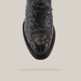 A top view of the Exotic Full Quilt Ostrich - Black - Round Toe shoe showcases its unique ostrich skin texture and distinctive raised bumps, reminiscent of Western design, against a light gray background.