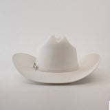 The 100X Independencia White is a luxurious cowboy hat made of full beaver fur, featuring a curved brim and a pin on the band, set against a plain light gray background.