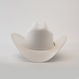 The 500X Superior White cowboy hat, made from belly beaver fur, boasts a wide brim and pinch front crown. This luxurious headwear stands out elegantly against a simple backdrop, ideal for those desiring premium Western style.