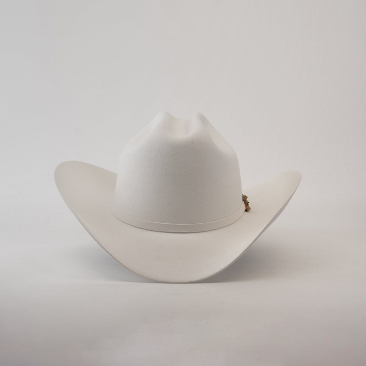 The 1000X Imperial White hat features a wide brim and slightly curved crown against a plain white background. Adorned with a small decorative emblem, this 100% genuine mink accessory exudes charm, sophistication, and style.