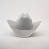 The 10X Jerarca Platinum, a gray fur felt cowboy hat with a wide brim and center crease, exudes classic western style. Its subtle hatband complements the design, reminiscent of Larry Mahans style, and is shown upright against a plain white background.