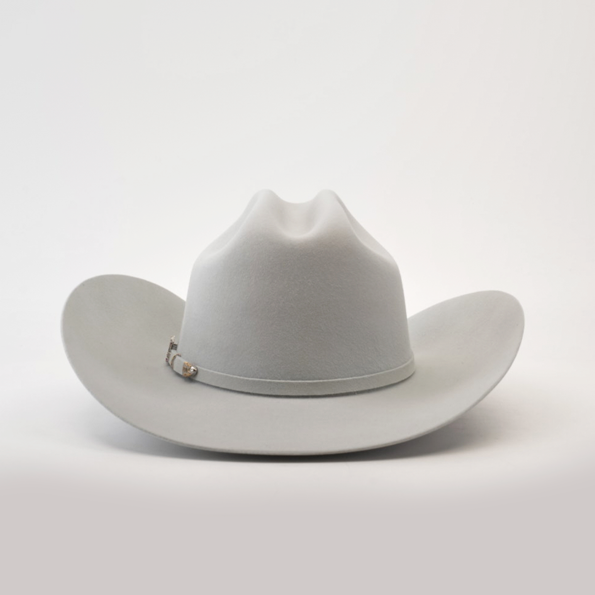 The 100X Independecia Platinum is a light grey cowboy hat from the Larry Mahan collection, featuring a wide brim and a stylish silver band, set on a smooth, neutral background.