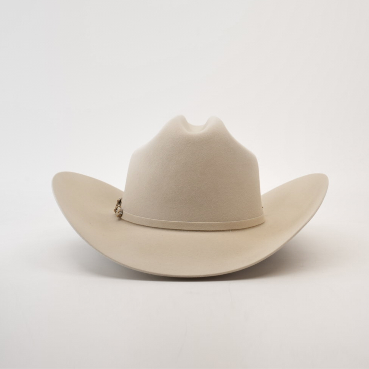 The Larry Mahan 100X Independencia Belly is a beige cowboy hat with a wide brim, dented crown, and a subtle decorative band. Crafted from premium full beaver fur, this luxury western headwear rests on a plain white background.