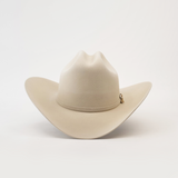 The 1000X Imperial Belly by Larry Mahan is a beige western hat with a wide brim and slightly creased crown, highlighted by a small decorative charm on the band, displayed against a plain white background.