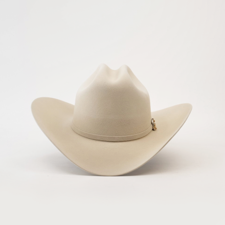 The 1000X Imperial Belly by Larry Mahan is a beige western hat with a wide brim and slightly creased crown, highlighted by a small decorative charm on the band, displayed against a plain white background.