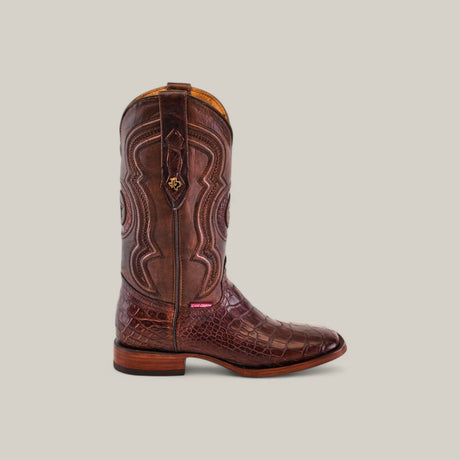 The Exotic American Alligator Belly - Brown - Square Toe boots feature intricate stitching on alligator leather with a crocodile texture against a neutral background, complete with a patterned shaft and wooden heel, embodying elegance and rugged style.