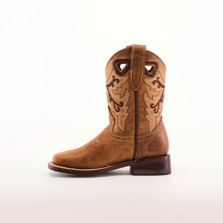 The Matcat Fawn - Square Toe boot exemplifies expert craftsmanship with decorative stitching and a pull tab. Made from premium leather, it features a slightly worn look and sturdy heel, set against a light, neutral backdrop.