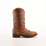 The Kiara Studs Fawn - Square Toe cowboy boot, crafted from premium brown leather, showcases intricate floral embroidery on the shaft and foot. With a low heel and pull tabs, it provides style and ease for fashion-forward young girls seeking standout pieces against a plain white background.