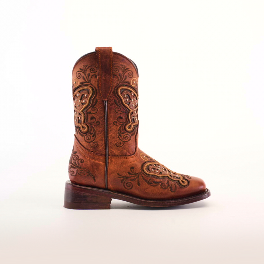 The Butterfly Studs Cogñac - Square Toe boot, showcased on a plain white background, features intricate embroidery and decorative patterns. Made from cowhide leather, it includes butterfly studs, a slight heel, and convenient pull straps at the top.