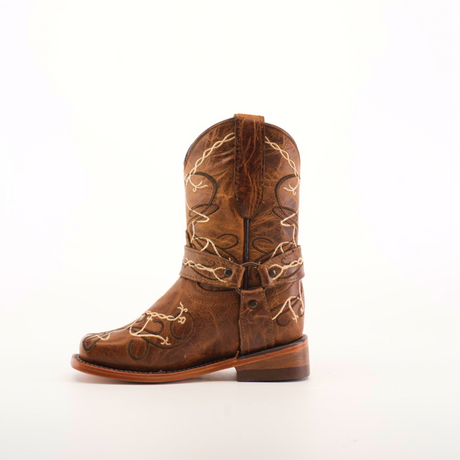 The Graffiti Yellow - Rodeo Toe is a single cowboy boot crafted from genuine leather, boasting intricate white stitching and decorative patterns. Its classic Western style, rounded toe, and slightly worn look make it perfect for young cowgirls seeking authentic flair against a plain white background.