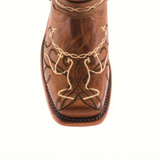 Close-up of a genuine leather cowboy boot, ideal for young cowgirls, featuring intricate white and dark brown embroidery with loops and curves on the toe. This striking boot boasts a square toe design reminiscent of the Graffiti Yellow - Rodeo Toe boots.