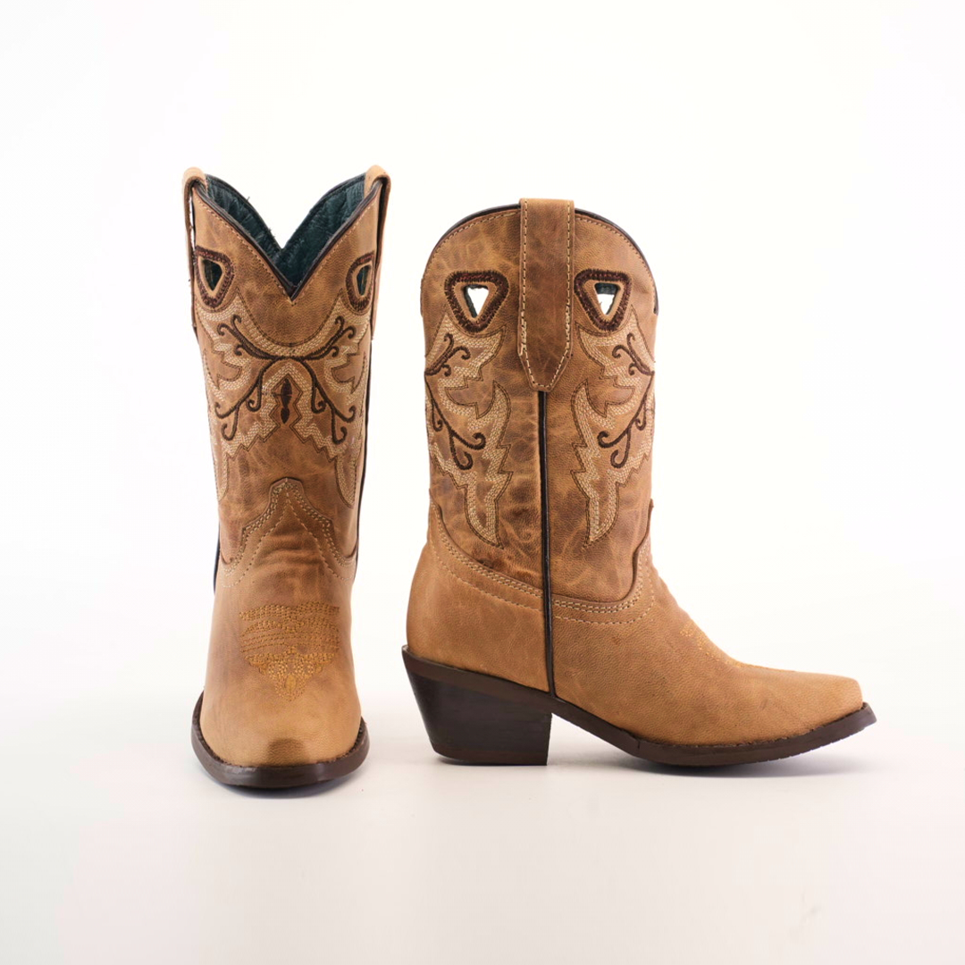 The Matcat Fawn - Snip Toe boots are handcrafted from premium tan leather, featuring decorative stitching, pointed toes, stacked heels, and triangular cutouts near the top. The left boot is angled forward while the right boot faces sideways.