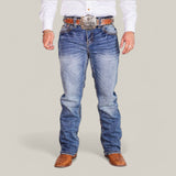 Dressed in a white long-sleeve shirt, brown leather cowboy boots, and Western Blue Straight Fit Embroidered Jeans - W435, a person exudes Western flair. With a large decorative belt buckle and slightly faded jeans, their hands rest casually by their sides.