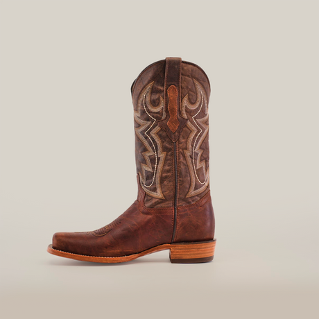 The Fresno Cogñac cowboy boot features a single brown design crafted from cowhide leather, highlighting intricate stitching on the shaft, a wide cutter toe, and a wooden heel against a plain white background.