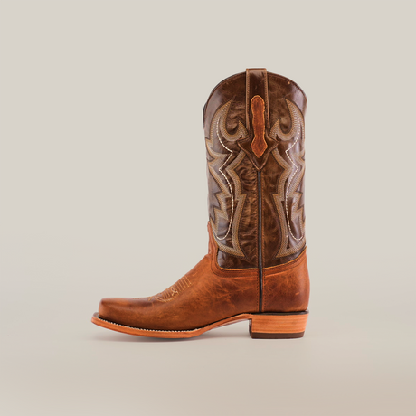 The Fresno Tan - Wide Cutter Toe cowboy boots boast premium cowhide leather with intricate stitching and a beautifully patterned shaft, standing upright on a plain white background, embodying the authentic cowboy lifestyle.