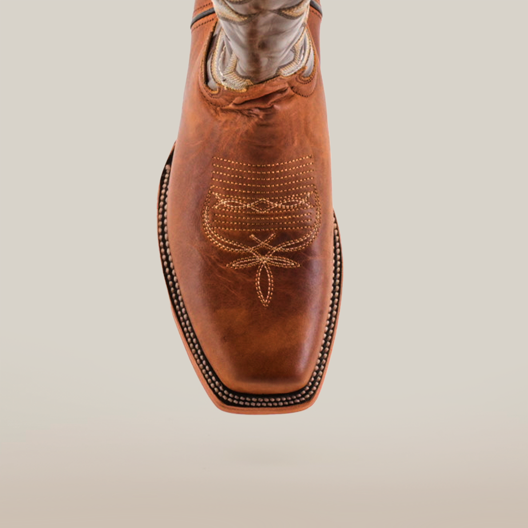 The Fresno Tan - Wide Cutter Toe cowboy boot features premium cowhide leather with intricate star-like stitching on the toe, embodying the cowboy lifestyle against a plain white background.