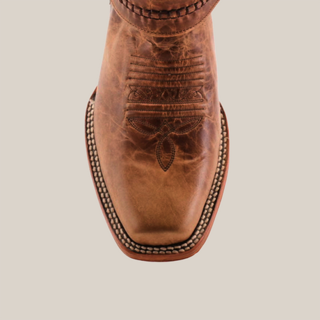 Close-up of the Siberia Fawn - Biker Toe boot, showcasing a brown, square-toed design with intricate toe stitching. Made from premium cowhide, its rustic leather features detailed embroidery and white edge stitching.