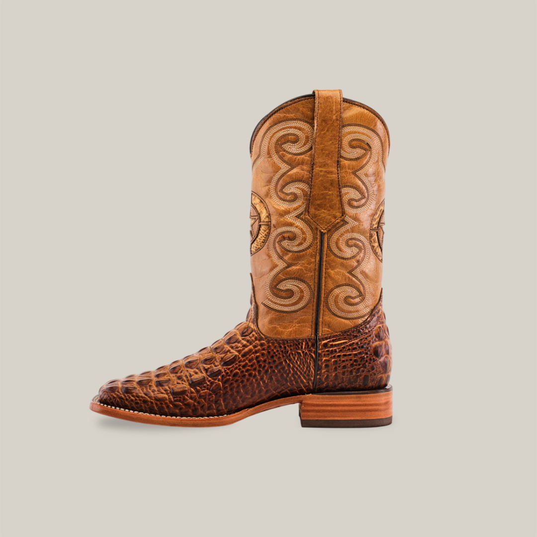 The Morelet Crocodile Print Orix - Square Toe boot features a light brown shaft with intricate swirl designs and a darker brown crocodile print foot, complete with a wooden heel and pointed toe, set on a plain white background.