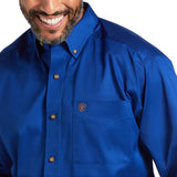 A person smiling in a Solid Twill Classic Fit Shirt Blue - 10006660, made of 100% cotton twill, with brown buttons and a small emblem on the pocket. The smart collar adds to its charm. Image highlights the upper chest and part of the face.