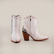 Presenting the Milan Chains Bootie Frost White - J Toe: stylish white ankle boots with zippers and metal studs from our exclusive Platinum Collection, crafted from premium leather with wooden block heels and a pointed toe, set against a plain white background.