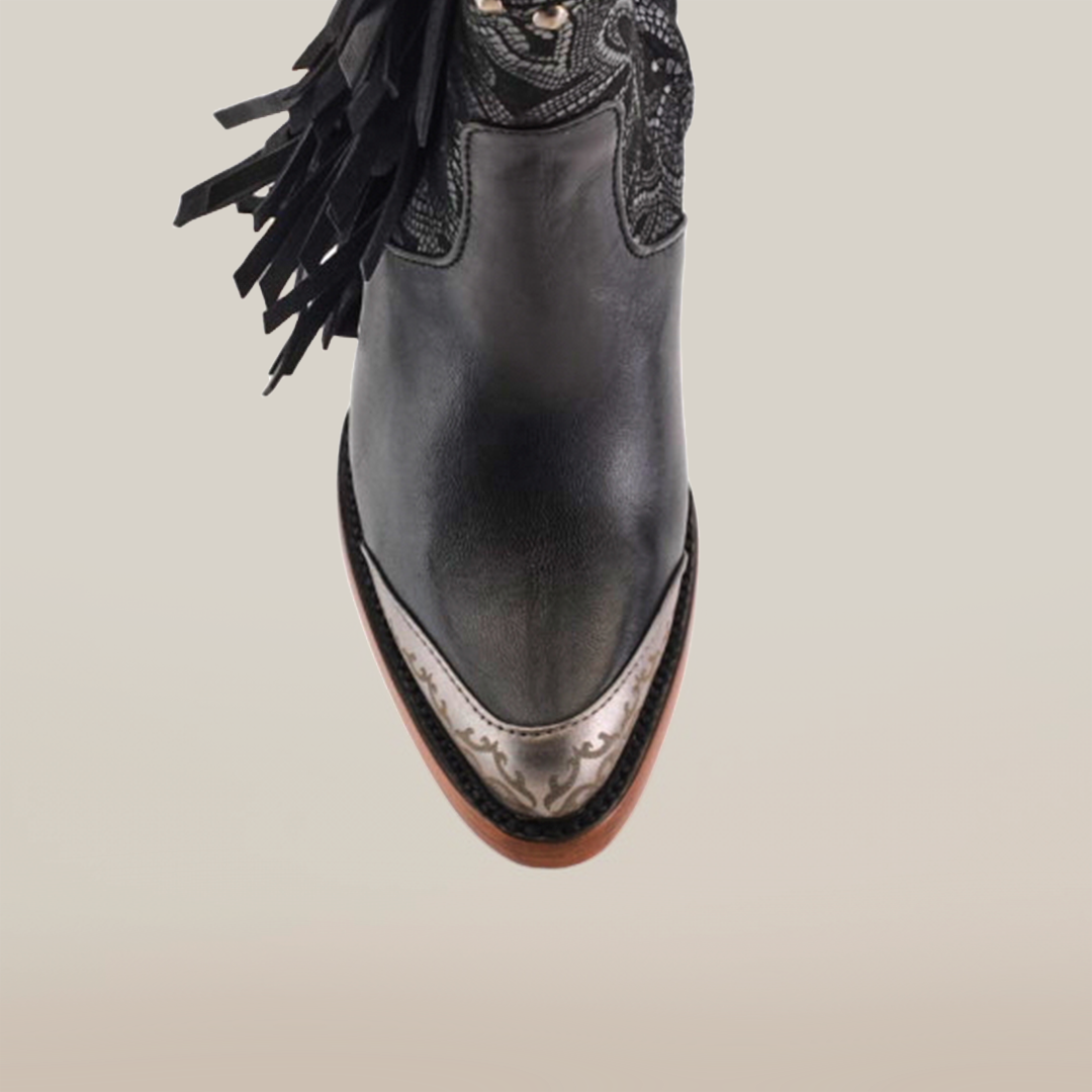 A top view of the Dallas Fringe Bootie Black - J Toe reveals luxury craftsmanship with premium leather, ornate embroidery, tassels, a pointed toe with metallic detailing, and a wooden sole.