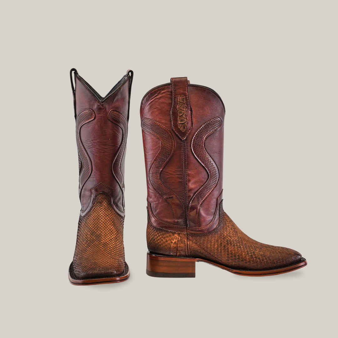 The Exotic Python - Diamond - Tamarindo - Square Toe boots showcase intricate stitching and a smooth texture. They feature a medium-length shaft with decorative pulls. The right boot is angled to highlight its striking appeal.