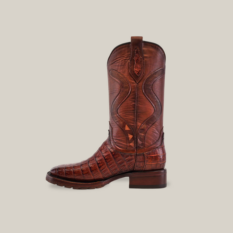 The Exotic Caiman Belly Tail in Diamond Brandy features a double sole square toe and showcases Western fashion with its textured leather and intricate stitching. Set against a white background, it is designed for durability with high-quality craftsmanship.