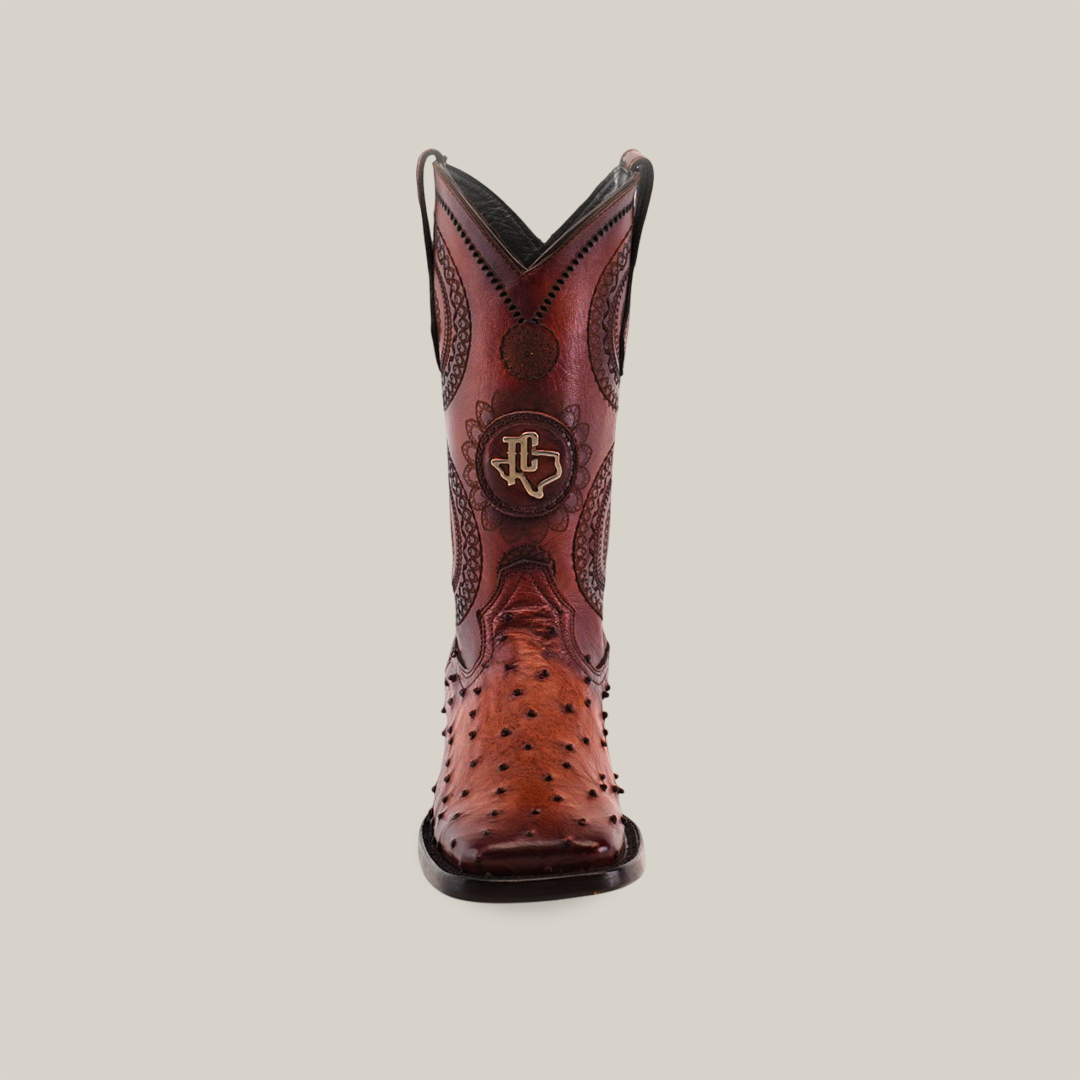 Front view of the Exotic Karoo Ostrich - Platinum - Honey cowboy boot with a square toe, showcasing intricate patterns and a logo on the upper part, set against a plain background.