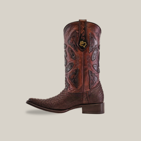 The Exotic Python - 4G - Matte Brown - Versy Toe from the Platinum Collection showcases a single ornately designed brown cowboy boot with intricate patterns and stitching on the shaft and foot, featuring a dark Goodyear welt sole. The embroidered pull strap stands out against a plain background.