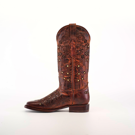 A single Marga Cruz Brick Mid Shaft boot, featuring a square toe design and crafted from premium brown leather with floral stitching and small studs, is set against a plain white backdrop.